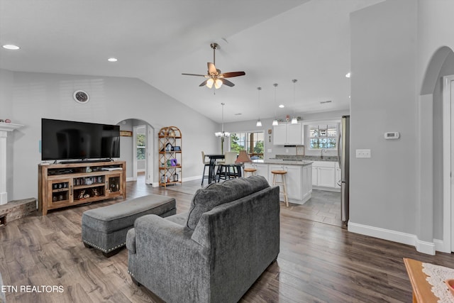 living room with high vaulted ceiling, ceiling fan, and hardwood / wood-style flooring