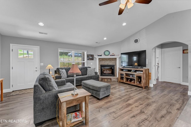 living room with ceiling fan, vaulted ceiling, and wood-type flooring