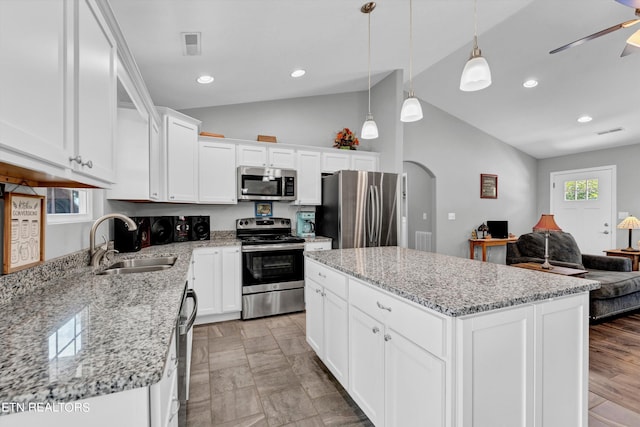 kitchen featuring stainless steel appliances, sink, white cabinets, a center island, and ceiling fan