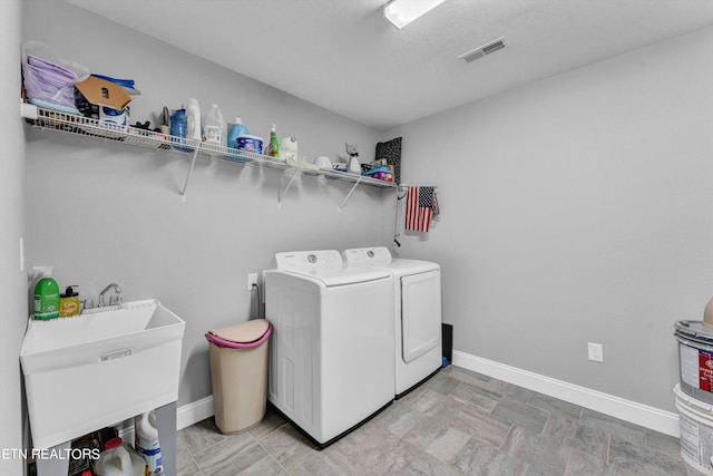 washroom featuring sink, light tile patterned flooring, and separate washer and dryer