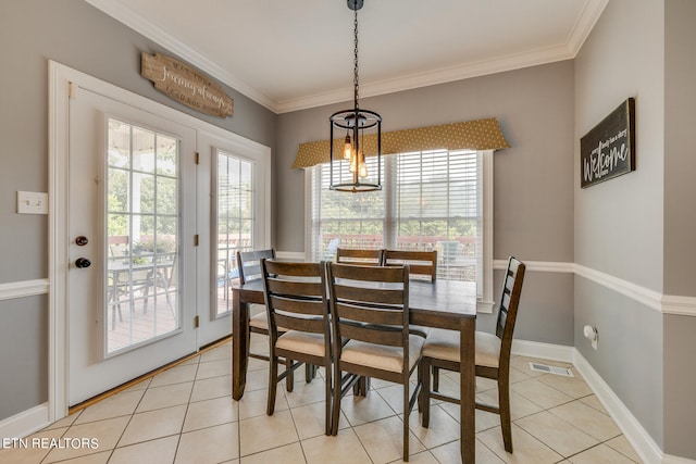 dining room featuring a wealth of natural light, light tile patterned flooring, and ornamental molding