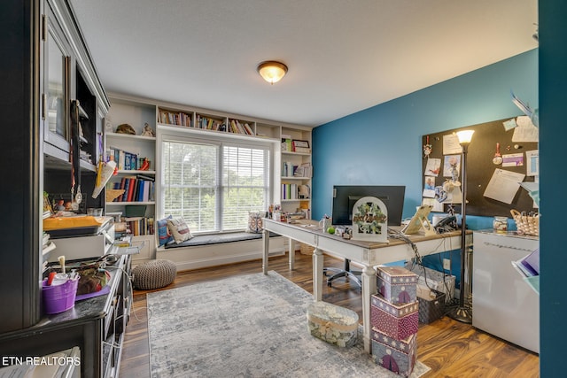 office area featuring built in shelves and hardwood / wood-style floors