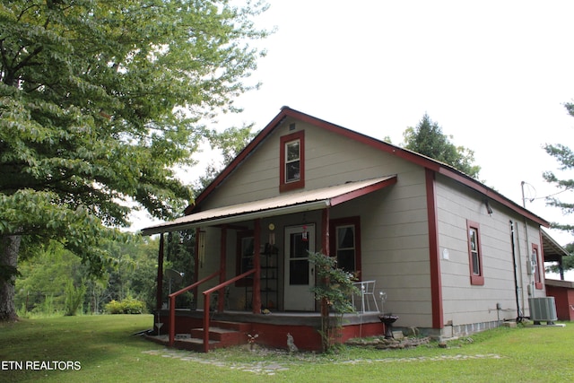 view of front of home featuring central AC unit, a front yard, and covered porch