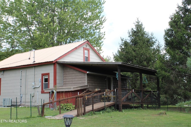 view of front of house with a wooden deck, central air condition unit, and a front lawn