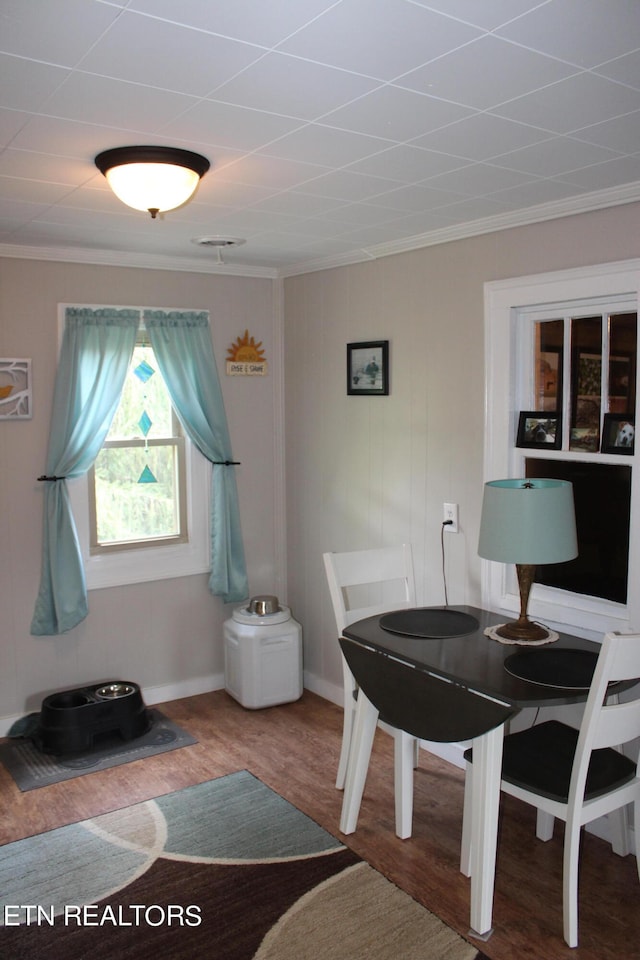 dining area with crown molding and hardwood / wood-style flooring