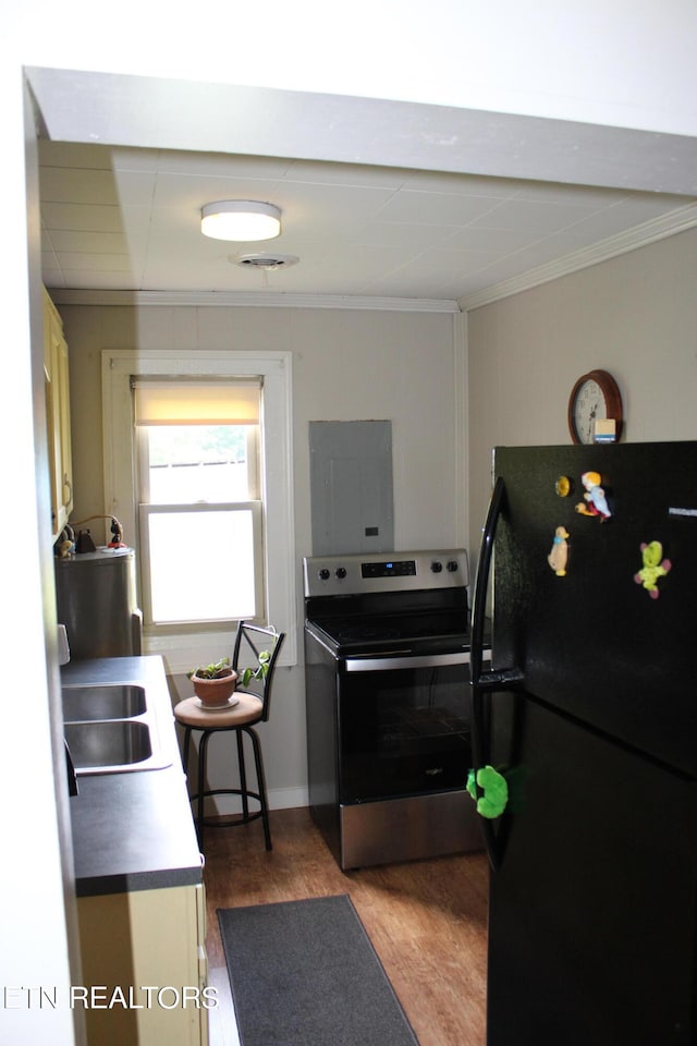 kitchen with electric panel, sink, black refrigerator, stainless steel electric range oven, and hardwood / wood-style flooring