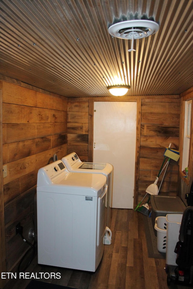 laundry area featuring wood ceiling, wooden walls, washing machine and dryer, and dark hardwood / wood-style flooring