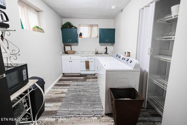 washroom with dark wood-style flooring, a sink, plenty of natural light, and washing machine and clothes dryer