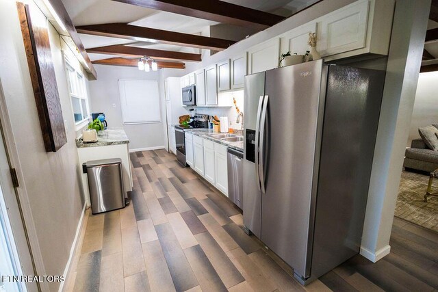 kitchen featuring beam ceiling, white cabinetry, appliances with stainless steel finishes, and dark hardwood / wood-style floors