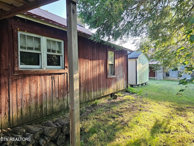 view of home's exterior with a storage shed and a yard