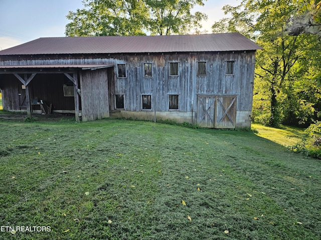 back of house featuring an outdoor structure and a yard