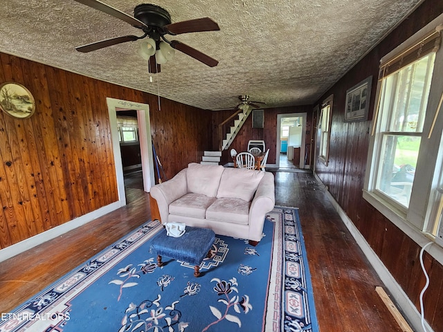 living room featuring a wealth of natural light, a textured ceiling, and dark wood-type flooring