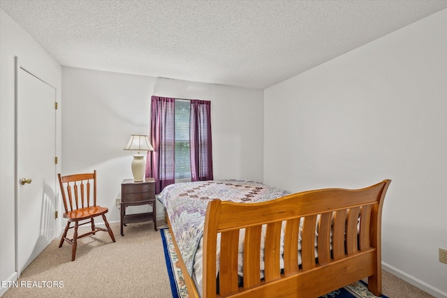 bedroom with light colored carpet, a textured ceiling, and baseboards