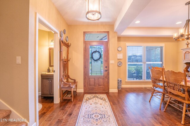 entrance foyer featuring dark hardwood / wood-style floors and a notable chandelier