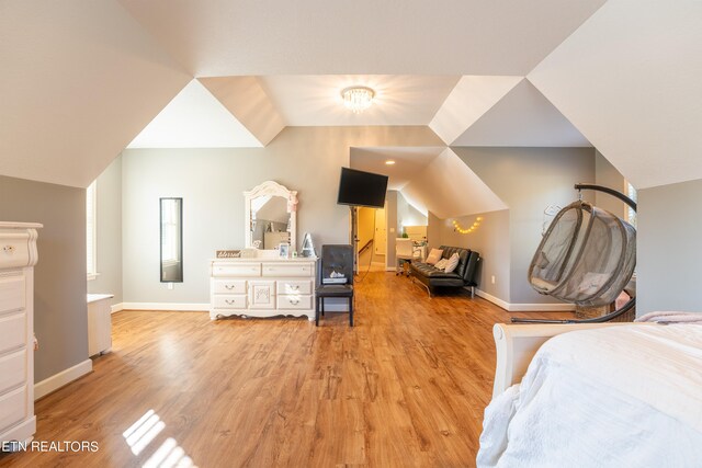 bedroom featuring light hardwood / wood-style floors and vaulted ceiling