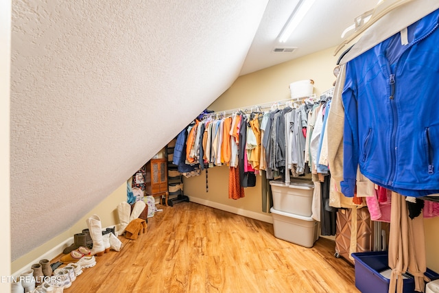 spacious closet featuring lofted ceiling and hardwood / wood-style floors