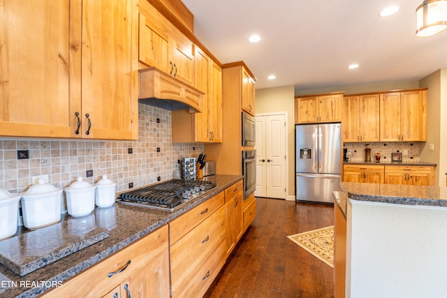 kitchen featuring backsplash, dark wood-type flooring, stainless steel appliances, custom range hood, and dark stone countertops