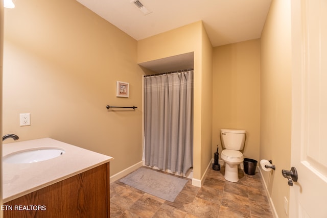 bathroom featuring a shower with curtain, vanity, and toilet