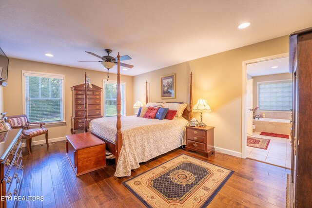 bedroom with ensuite bath, ceiling fan, and dark hardwood / wood-style floors