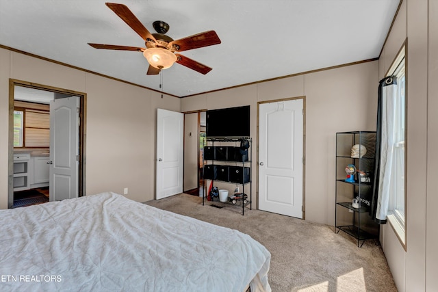 carpeted bedroom with ceiling fan and ornamental molding