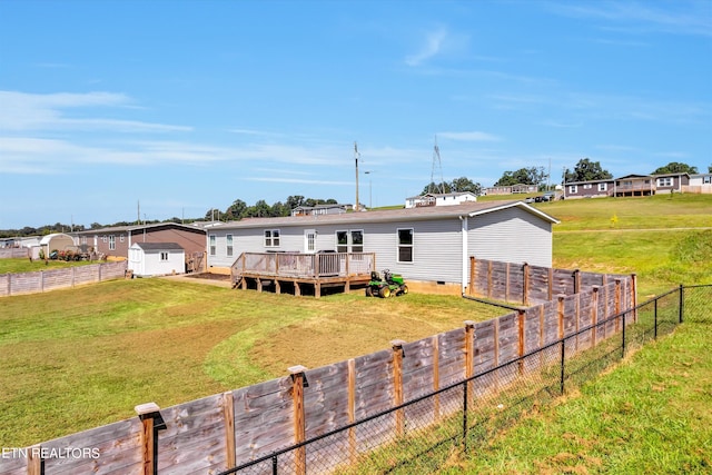 rear view of property featuring a wooden deck and a yard