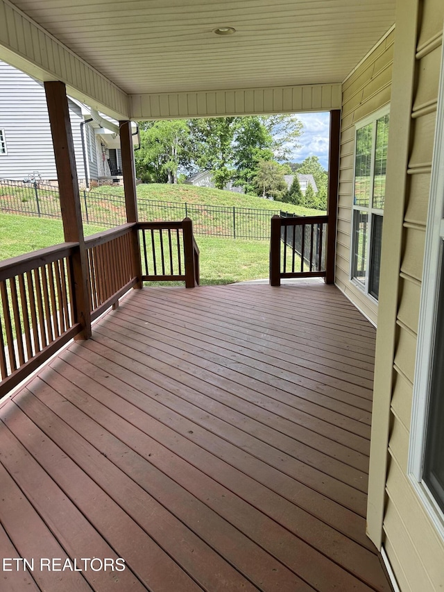 wooden deck featuring a fenced backyard and a lawn