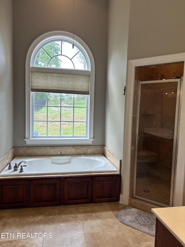 full bathroom featuring vanity, tile patterned floors, a bath, and a shower stall