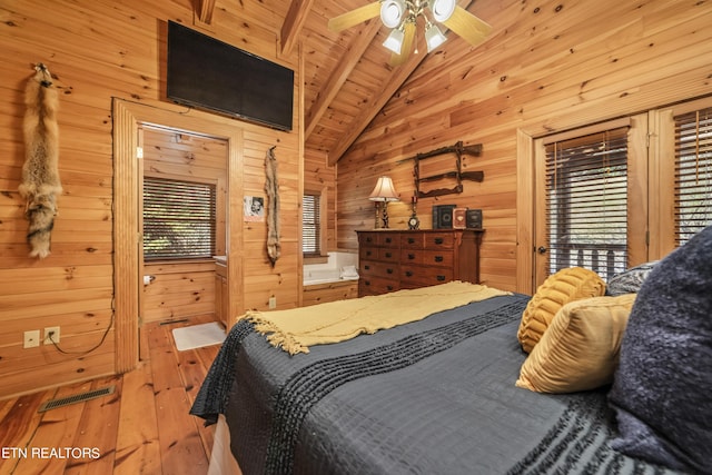 bedroom featuring visible vents, lofted ceiling, light wood-style flooring, wood ceiling, and wood walls