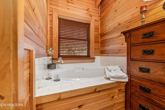 bathroom with a tub to relax in and wooden walls