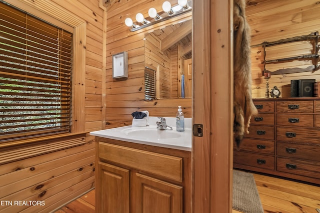 bathroom with wood finished floors, vanity, and wooden walls