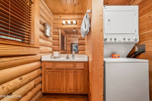 washroom with log walls, stacked washer and clothes dryer, sink, wooden ceiling, and hardwood / wood-style flooring