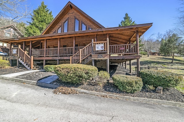 log home featuring stone siding and stairway