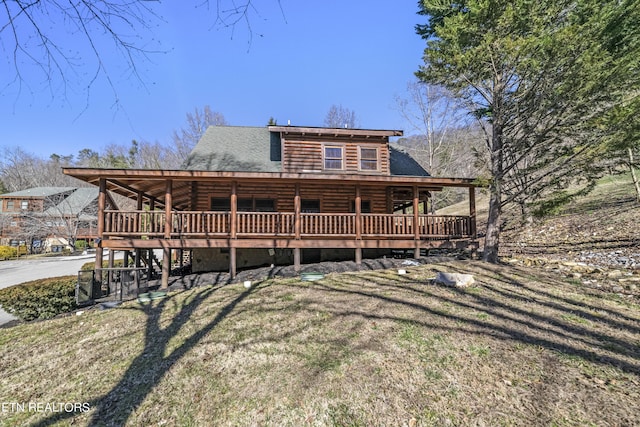 log home with a wooden deck, a front lawn, and log siding