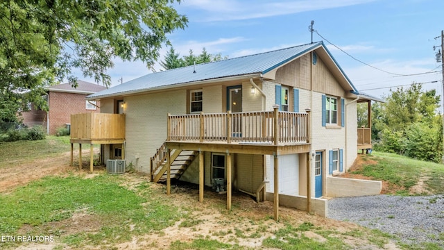 back of property featuring a deck, central AC, and a garage