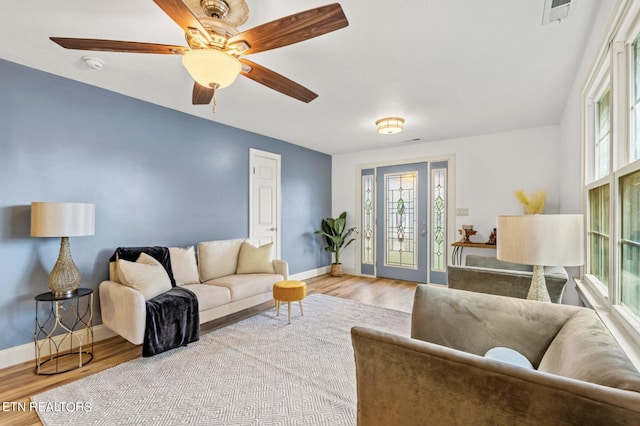 living room featuring ceiling fan and light hardwood / wood-style floors