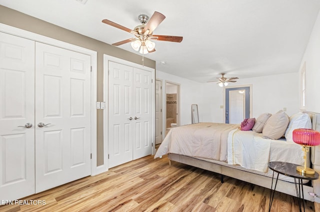 bedroom with light wood-type flooring, two closets, and ceiling fan