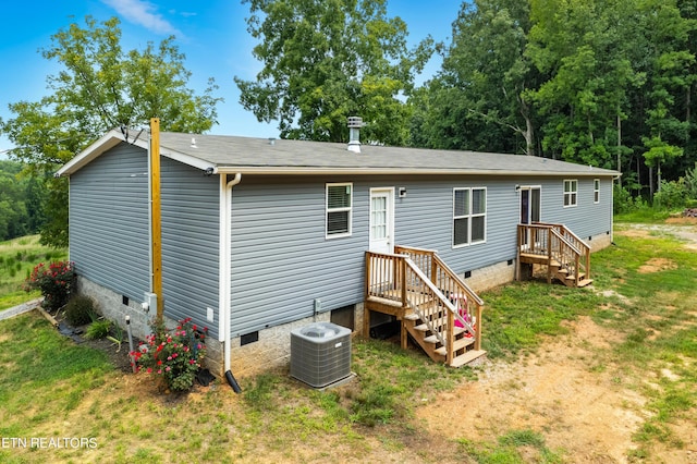 rear view of property featuring crawl space, a lawn, and cooling unit