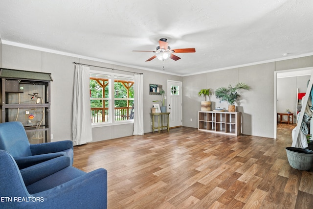 living room featuring hardwood / wood-style flooring, ornamental molding, and ceiling fan