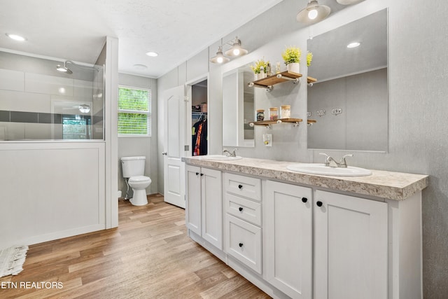 bathroom with double sink vanity, hardwood / wood-style flooring, toilet, and ornamental molding