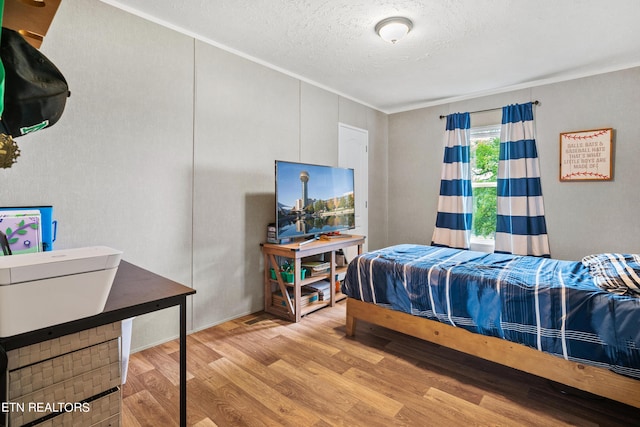 bedroom featuring a textured ceiling and wood finished floors