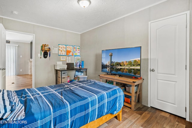 bedroom with a textured ceiling and wood finished floors