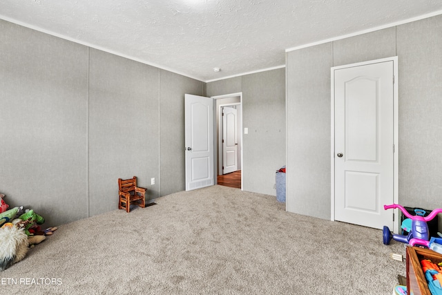 interior space featuring a textured ceiling, carpet, and crown molding