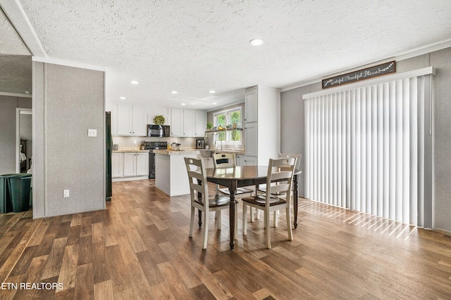 dining area with a textured ceiling and hardwood / wood-style floors