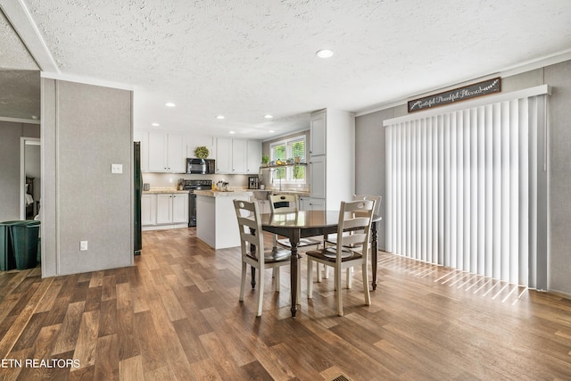 dining area with a textured ceiling, dark wood-type flooring, and recessed lighting