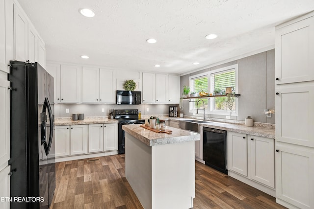 kitchen with sink, black appliances, white cabinets, a center island, and dark wood-type flooring