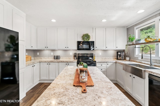 kitchen featuring sink, black appliances, a textured ceiling, white cabinets, and dark wood-type flooring