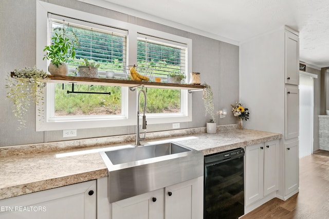 kitchen featuring black dishwasher, hardwood / wood-style flooring, sink, and white cabinets