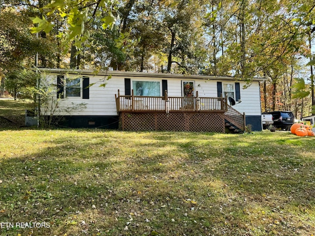 manufactured / mobile home with a front yard and a wooden deck