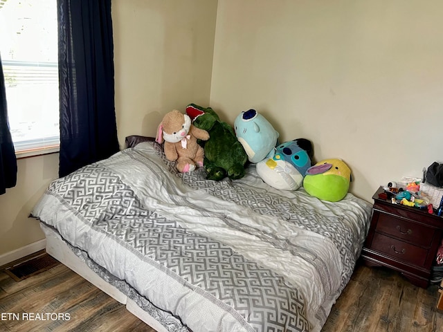 bedroom with dark wood-type flooring