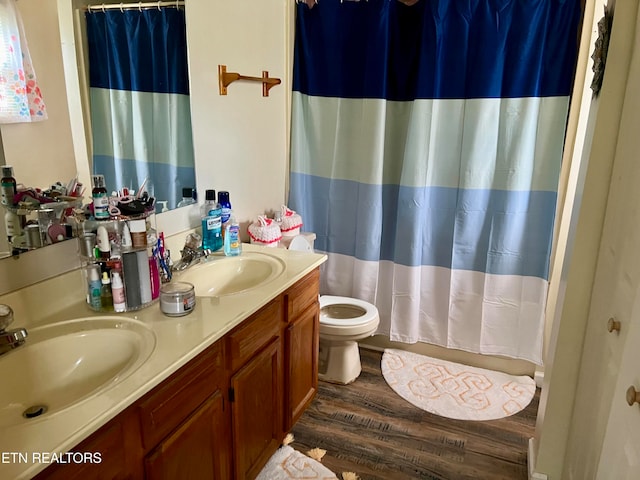 bathroom featuring toilet, walk in shower, vanity, and wood-type flooring